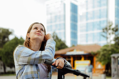 Portrait of young woman standing in city