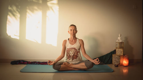 Full length portrait of woman sitting at home