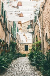 Bells hanging over narrow alley amidst buildings in city