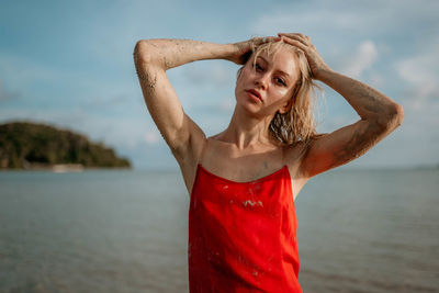 Portrait of young woman standing at beach