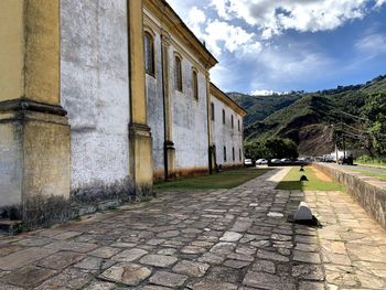 Empty street amidst buildings against sky