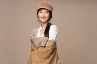 Portrait of a smiling young woman against gray background