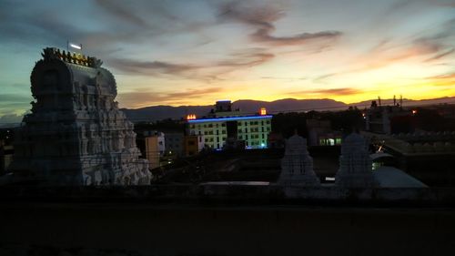 View of buildings against cloudy sky at sunset
