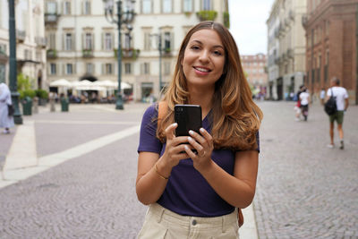 Portrait of smiling young woman using mobile phone