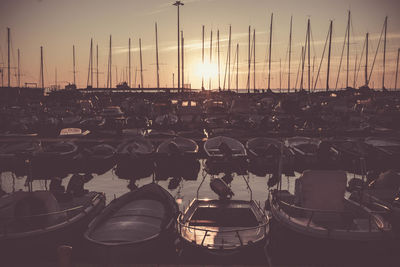 Boats moored at harbor during sunset