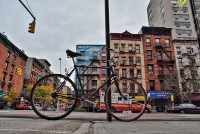 Bicycles parked on road by buildings in city