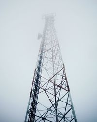 Low angle view of electricity pylon against clear sky