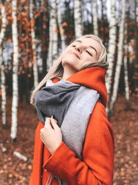 Midsection of woman standing by tree during winter