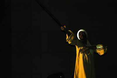 Low angle view of person holding umbrella at night