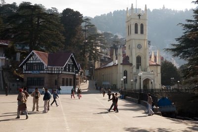 People walking on road along built structures