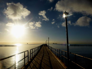 Jetty in sea against sky during sunset