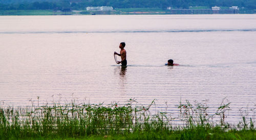 Men standing on lake shore