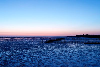 Scenic view of sea against clear sky at sunset