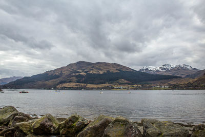 Calm lake against rocky mountain range