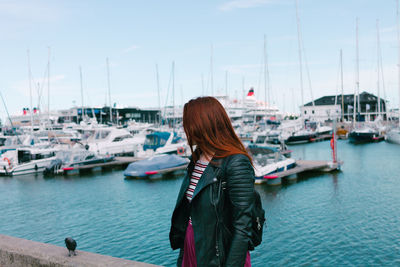 Sailboats moored at harbor against sky