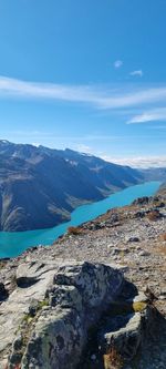 Scenic view of sea and mountains against blue sky