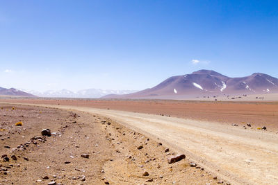 Scenic view of desert against blue sky