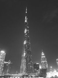 Low angle view of illuminated buildings against sky at night