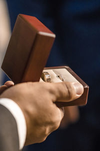 Close-up of man holding ring box