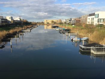 Boats moored in city against sky