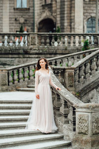 Young woman standing by building