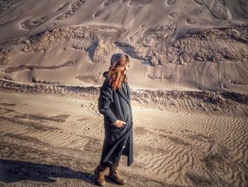 Full length of woman standing on sand