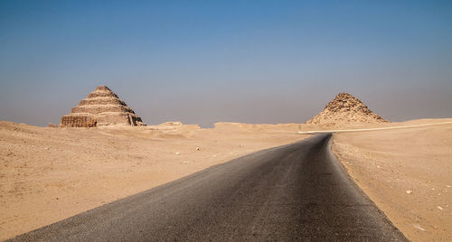 Road amidst desert against clear sky
