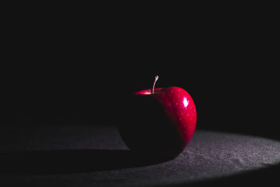 Close-up of apple on table against black background