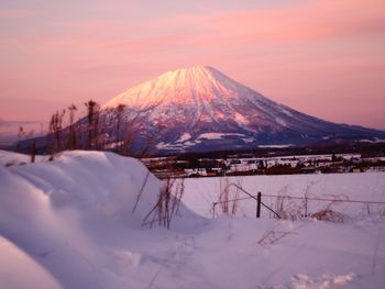 Snow covered mountain against sky during sunset