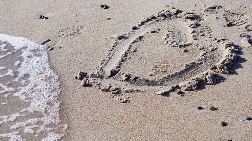 High angle view of footprints on sand at beach