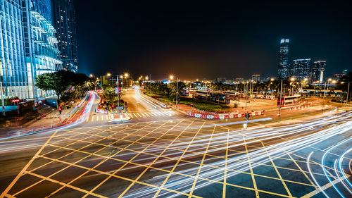 Light trails on city street against clear sky at night