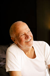 Happy thoughtful senior man sitting at home