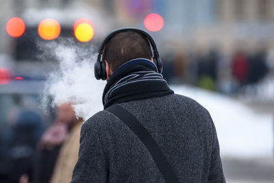 Rear view of man standing in city during winter