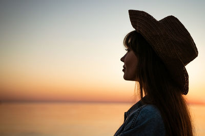 Portrait of woman against sea during sunset