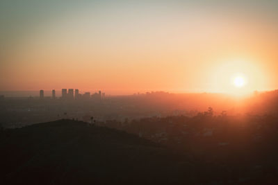 Scenic view of silhouette buildings against sky during sunset