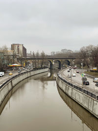 Bridge over river against sky in city