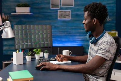 Man using mobile phone while sitting on table