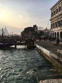 View of boats in city at sunset