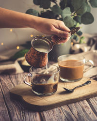 Hand holding coffee cup on table