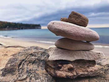 Stack of rocks on beach against sky