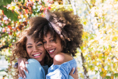 Close-up of happy females embracing outdoors