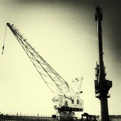 Low angle view of crane against sky