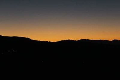 Scenic view of silhouette mountains against clear sky