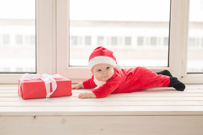 Portrait of baby boy sitting on window