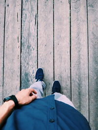 Low section of man standing on floorboard