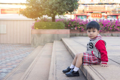 Portrait of cute boy sitting outdoors