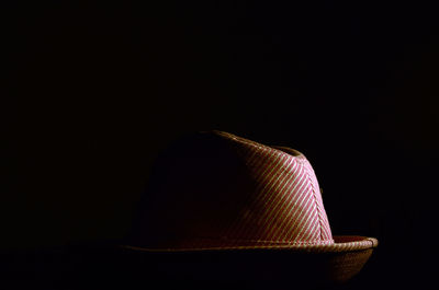 Close-up of hat against black background