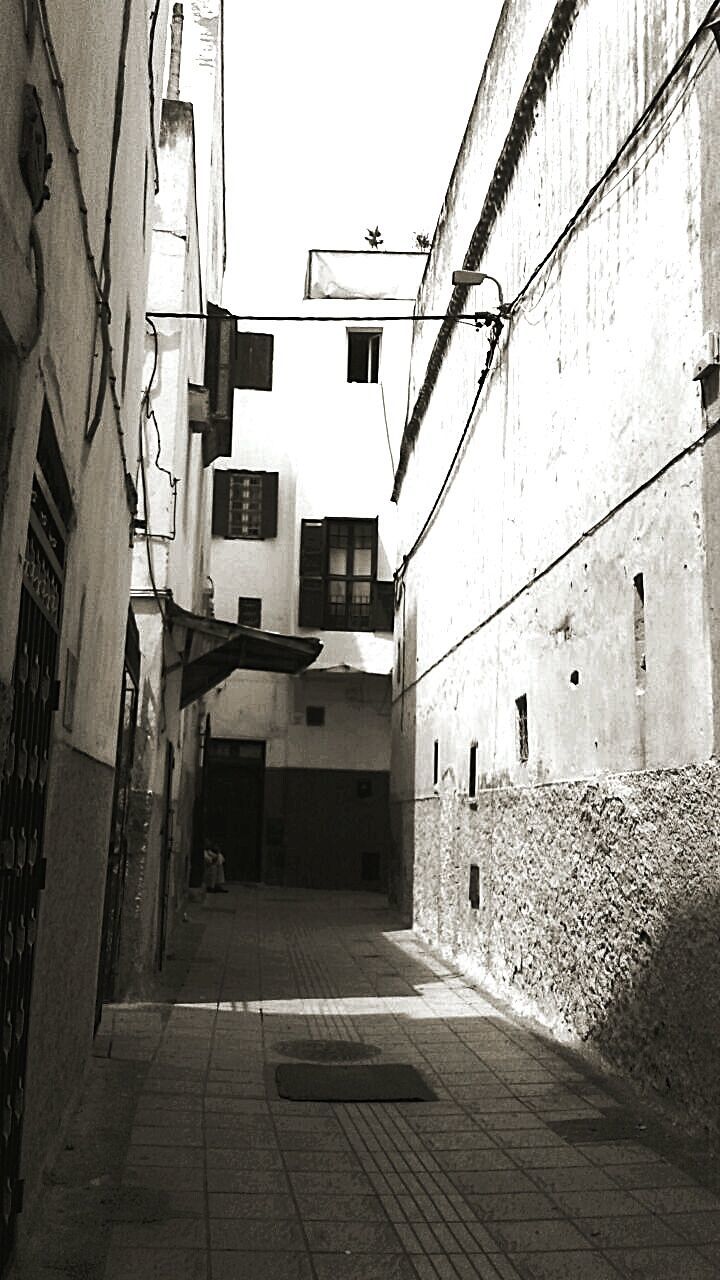 NARROW ALLEY WITH BUILDINGS IN BACKGROUND