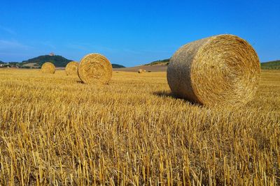 Hay bales on field against sky