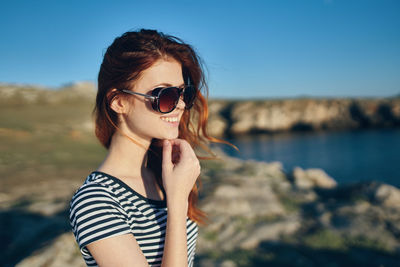 Portrait of young woman wearing sunglasses at beach